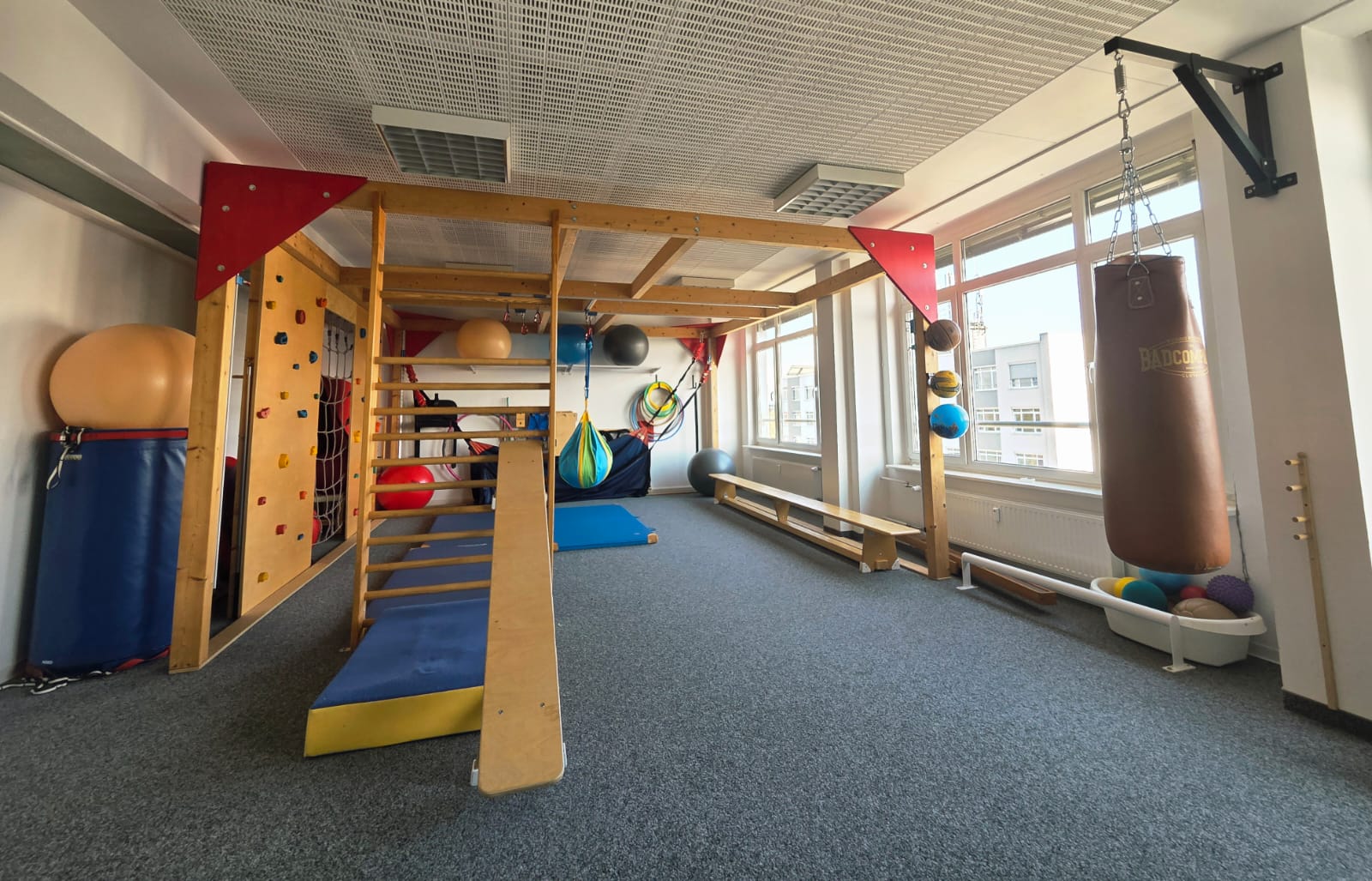 Bewegungsraum mit Kletterwand, Sprossenwand und verschiedenen Sportgeräten